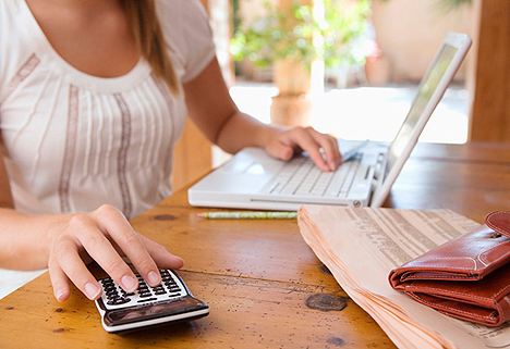 Woman with calculator and laptop